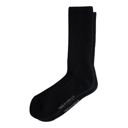Une paire de chaussettes de sport noires mi-mollet empilées sur un fond blanc uni