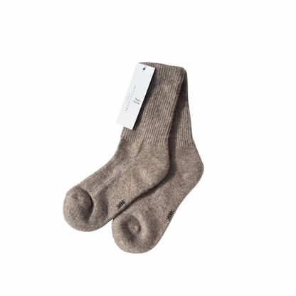 Pair of brown Yak socks with a white label on a white background