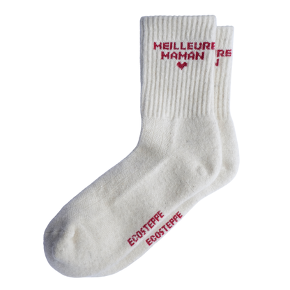 chaussette en laine de mongolie, couleur blanc avec ecriture meilleure maman en rouge et un petit coeur en rouge le tout sur un fond blanc