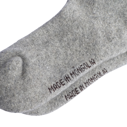 dessous de pied d'une chaussette en laine épaisse grise sur un fond blanc