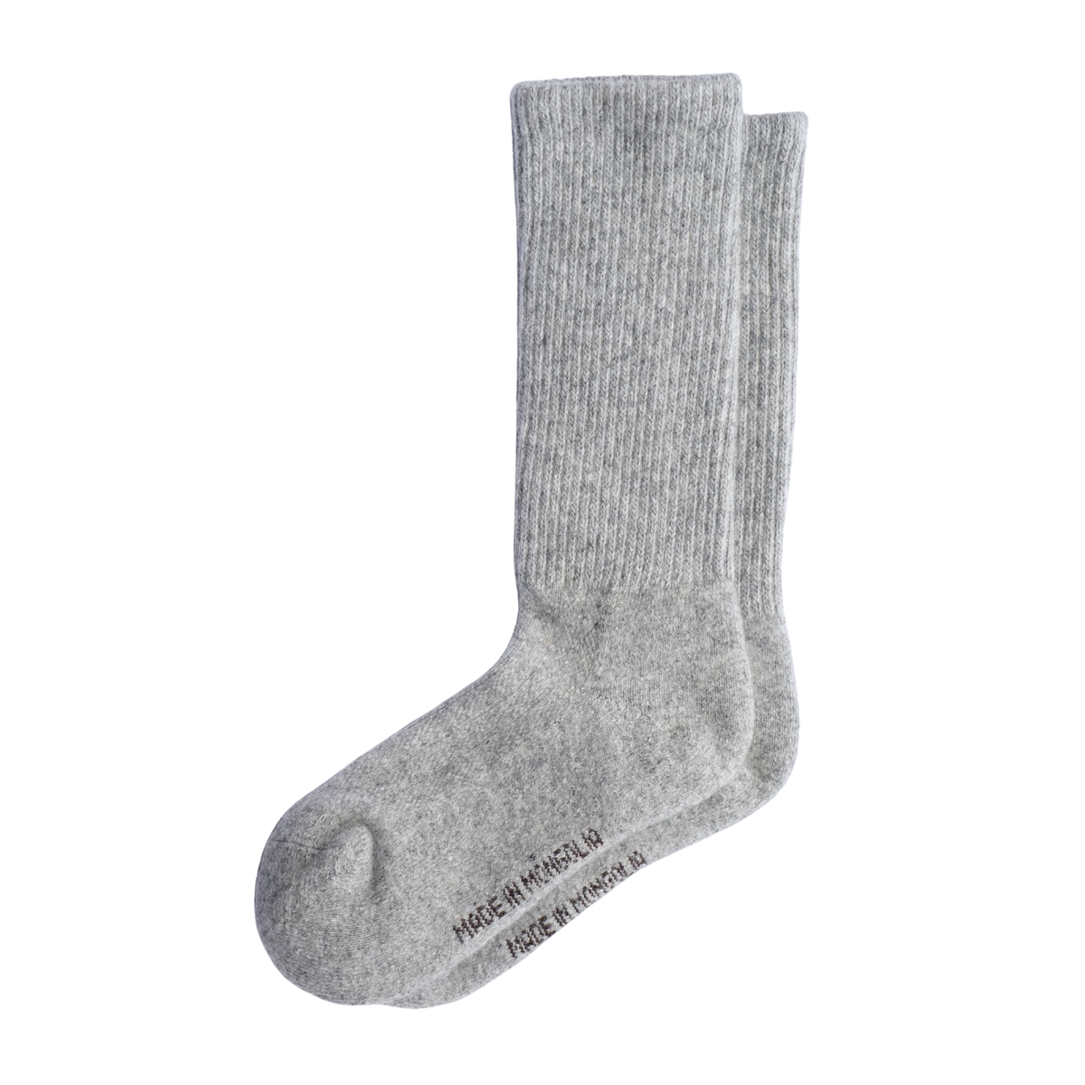 Une paire de chaussettes en laine côtelée gris clair présentée sur un fond blanc uni, avec la mention « MADE IN MONGOLIA » imprimée sur la semelle.