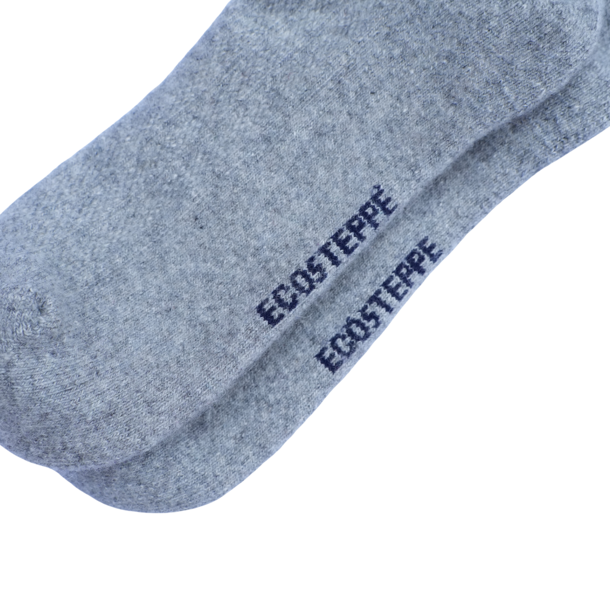 Gros plan sur une chaussette gris chiné portant le nom de la marque « ECOSTEPPE » imprimé en bleu marine, sur fond blanc uni.